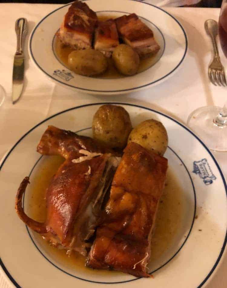 Porzione di cochinillo asado, il maialino da latte arrosto servito con patate al ristorante Botín di Madrid